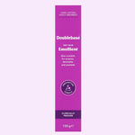 A tall magenta-purple tube of Doublebase Dry Skin Emollient 100g, shown vertically against a very pale lavender background. The tube features white text and a circular purple 'Prescription Only' seal.