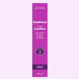 A tall magenta-purple tube of Doublebase Dry Skin Emollient 100g, shown vertically against a very pale lavender background. The tube features white text and a circular purple 'Prescription Only' seal.