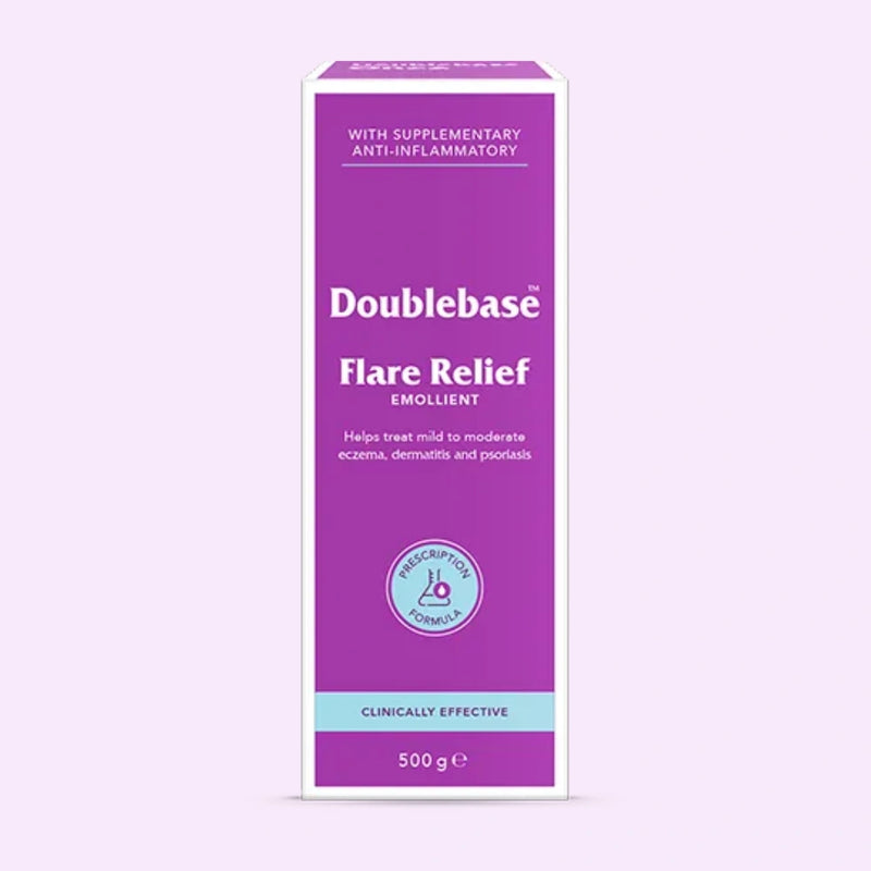 A 500g box of Doublebase Flare Relief Emollient, featuring a purple and white design with a light blue accent band at the bottom, set against a pale lavender background.