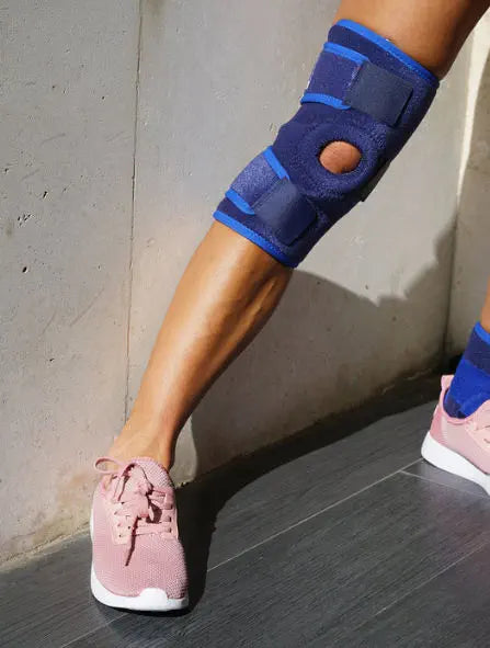 Knee support bandage in use with a person wearing sneakers, showing knee protection.