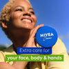 Person holding a Nivea cream container with a blue sky background