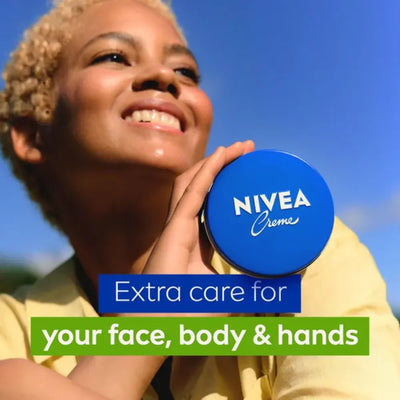 Person holding a Nivea cream container with a blue sky background