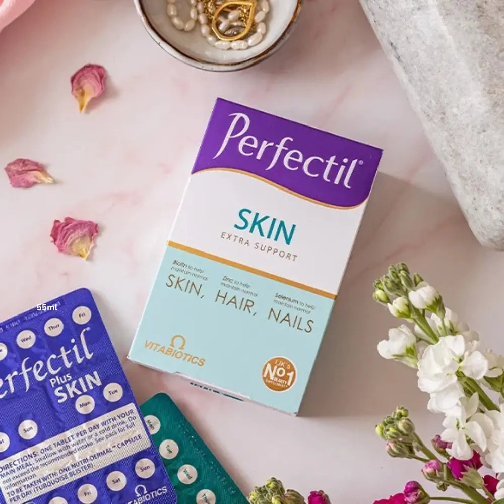 Perfectil Skin supplement packaging on a pink surface with flowers and jewelry.