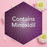 A purple hexagonal badge on a pink background with white flowers and petals, containing the text 'Contains Minoxidil' in white.