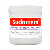 A white plastic jar of Sudocrem Antiseptic Healing Cream with a white lid, featuring a red and white label with purple text, on a plain white background.