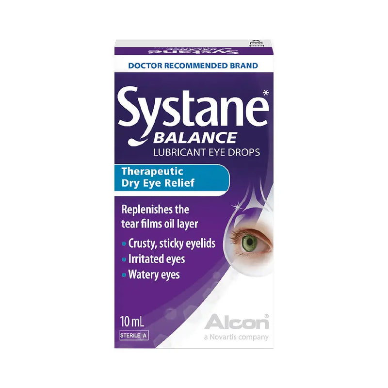 A box of Systane Balance Lubricant Eye Drops by Alcor on a plain white background. The packaging is primarily purple and white with a blue banner and a graphic of a human eye on the right side.