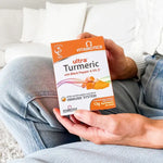 Person holding Vitabiotics Ultra Turmeric pack, highlighting immune support benefits.