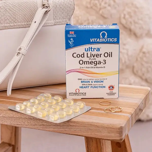Vitabiotics Ultra Cod Liver Oil Plus Omega-3 with a blister pack of 60 capsules on a wooden table.