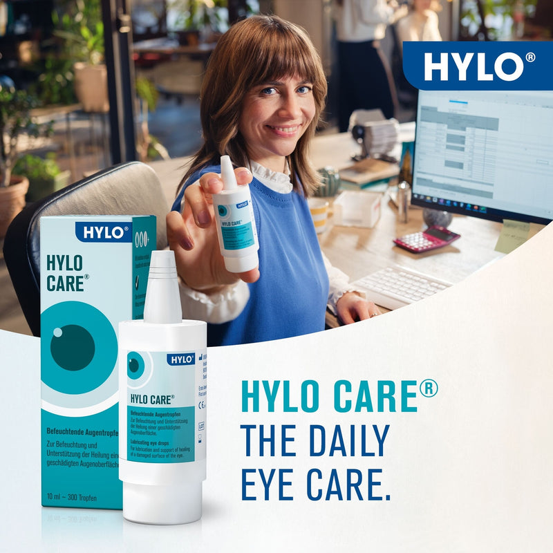 Woman holding a bottle of HYLO Care eye care product in an office setting with HYLO branding.